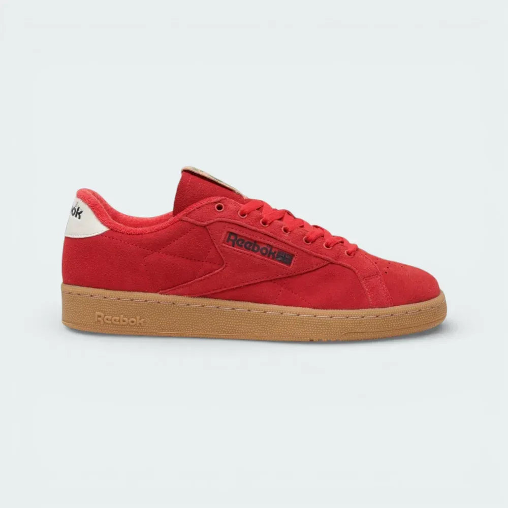 Side profile of the Reebok Club C Grounds UK in Vector Red suede, showing the Glen Green side stripes and the vintage gum rubber outsole. Main image