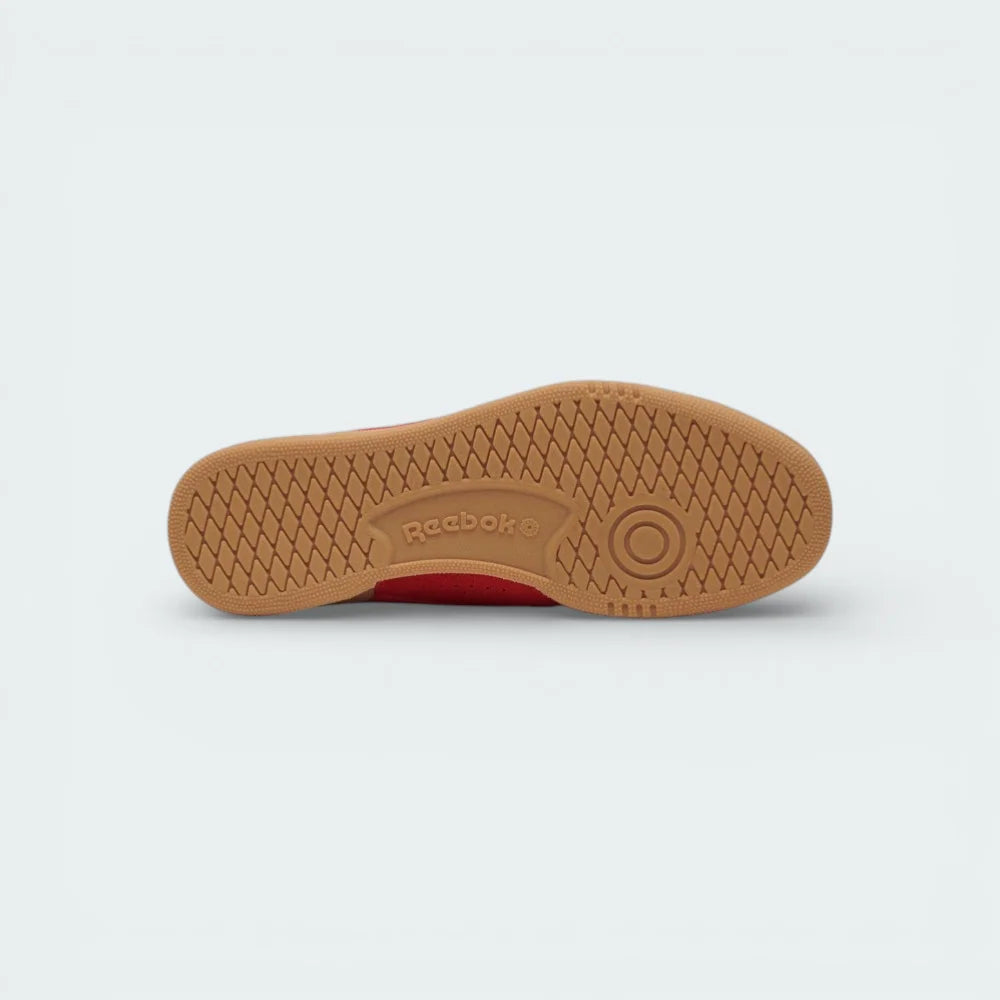 View of the gum rubber outsole, showcasing the heritage traction pattern and the embossed Reebok branding.