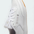 Close-up zoom on the front of the Reebok Classic Club C 85 Women's white trainers, showing the leather texture, perforated toe box, and lacing system.