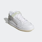 Angled view of the Adidas Forum Low Women's trainers in cloud white, side on, showcasing their iconic silhouette and clean, monochromatic design.
