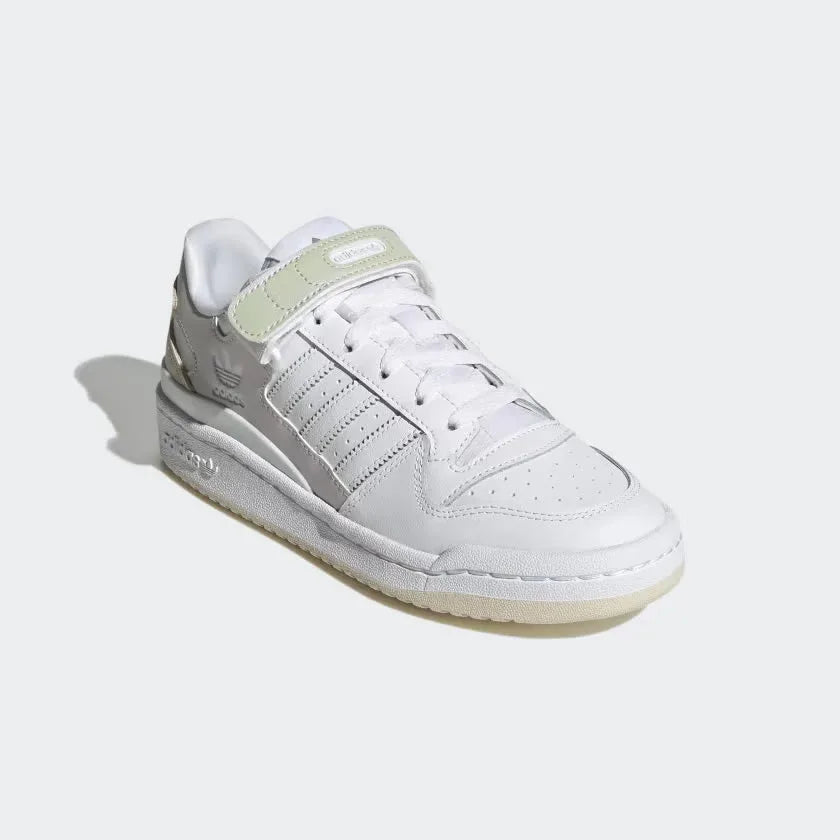 Angled view of the Adidas Forum Low Women's trainers in cloud white, side on, showcasing their iconic silhouette and clean, monochromatic design.
