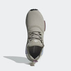 Top-down view of a pair of Adidas NMD_R1 women's trainers in grey, highlighting the lace-up closure and soft knit texture.