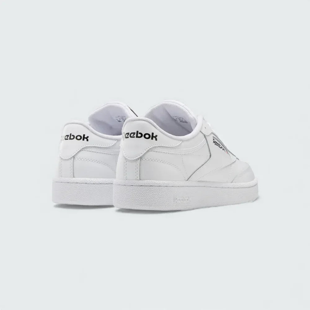 Angled view of two Reebok Classic Club C 85 Unisex white trainers from behind side by side, showcasing their timeless aesthetic and classic court design.