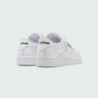 Angled view of two Reebok Classic Club C 85 Unisex white trainers from behind side by side, showcasing their timeless aesthetic and classic court design.