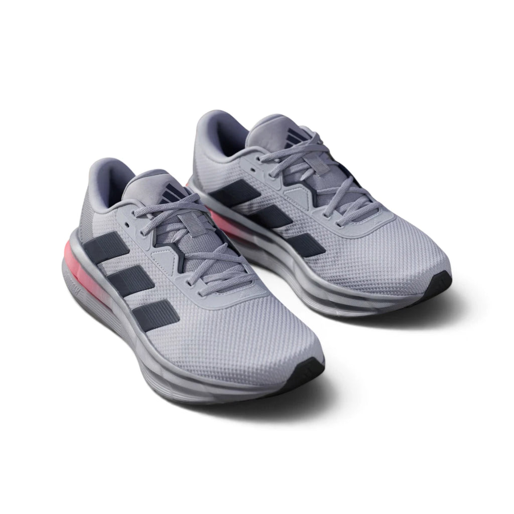 Overhead view looking down at the laced silver running shoes, displaying the tonal flat laces, breathable tongue label, and comfortable branded insole.