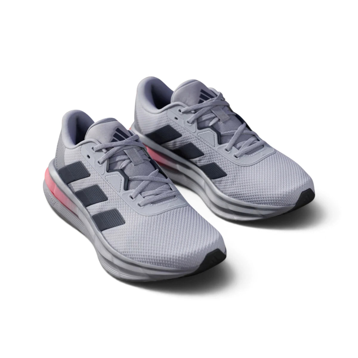 Overhead view looking down at the laced silver running shoes, displaying the tonal flat laces, breathable tongue label, and comfortable branded insole.