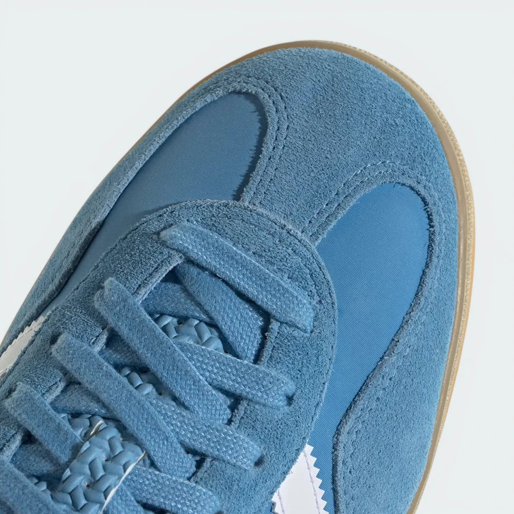 Zoom Looking at the Front of the Shoes and Laces: A close-up of the fine suede grain and the precision stitching on the light blue toe box.