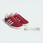 Red Adidas sneakers with white laces on a light gray background