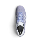 Direct overhead view of the shoe, displaying the classic suede toe overlay, flat violet laces threaded through clean punched eyelets, textured white tongue crowned with the adidas Trefoil logo, and comfortable interior footbed.
