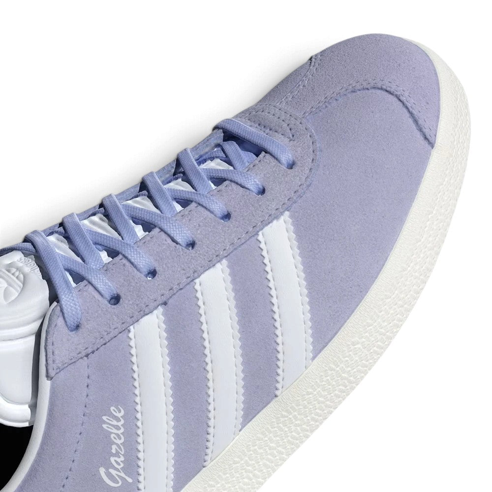 Macro focus on the forefoot, detailing the fine velvety nap of the Violet Tone suede, classic T-toe stitch contour, and flat violet laces passing through clean punched eyelets.