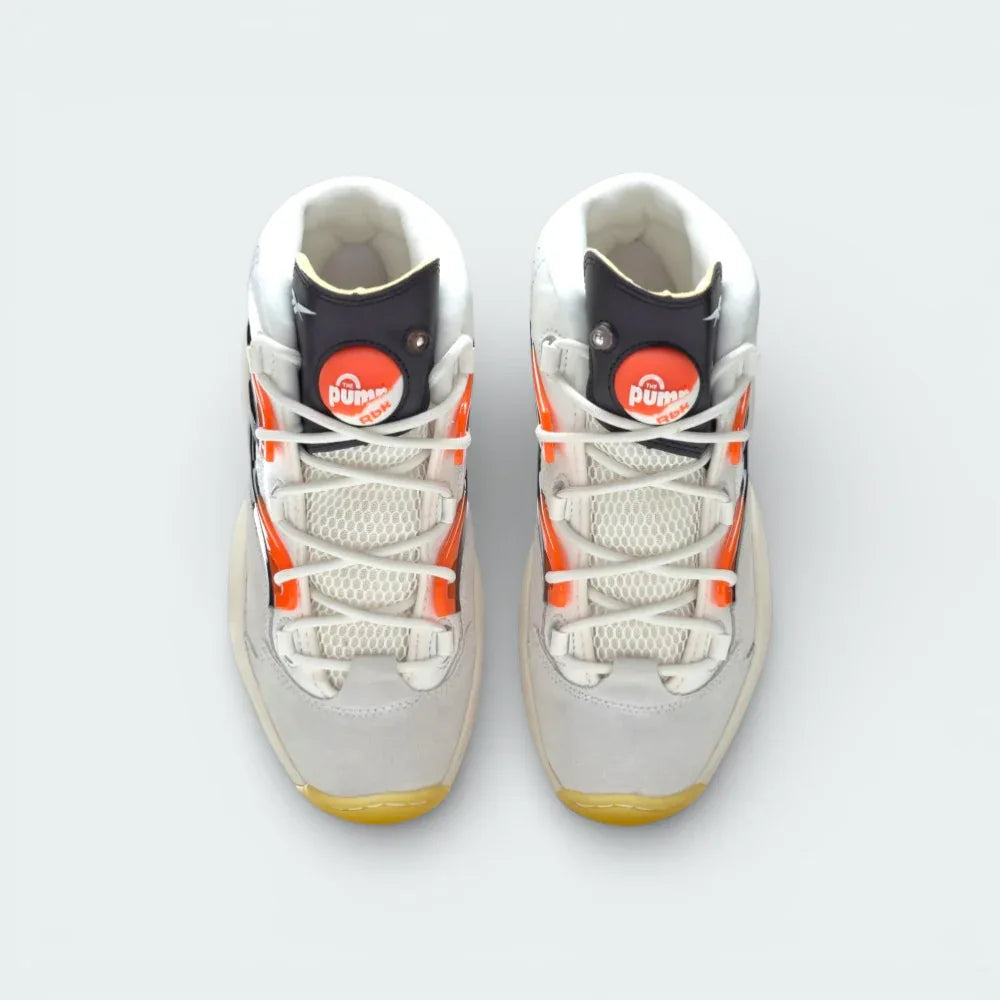 Top-down view of the "Pump Universe" trainers, highlighting the airy mesh panels, white lacing, and the functional orange Pump buttons.