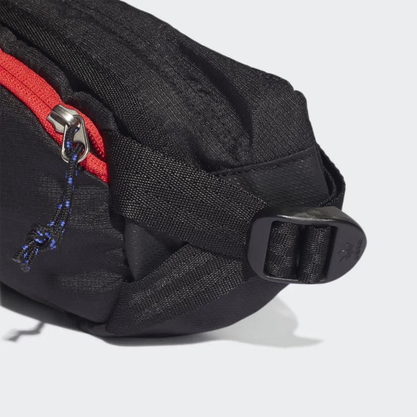 Side profile of the Adidas Adventure Waist Bag in black, highlighting its compact depth and the ripstop fabric texture.