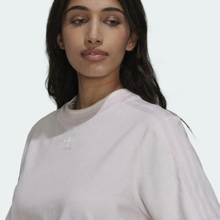 Close-up zoom on the fabric of the Adidas Tennis Luxe Tee Dress in ambient blush pink, showing the soft cotton jersey texture and any embroidered Adidas logo detail.