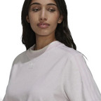 Close-up zoom on the fabric of the Adidas Tennis Luxe Tee Dress in ambient blush pink, showing the soft cotton jersey texture and any embroidered Adidas logo detail.