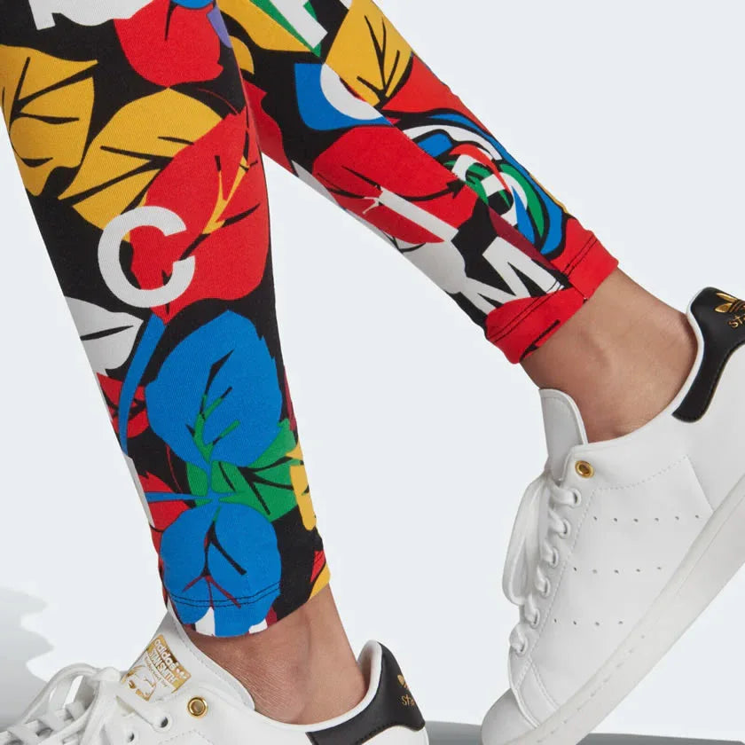 A full-length view of the Adidas x Rich Mnisi Graphic Leggings, showing the continuation of the multi-color rose print and the tapered fit.