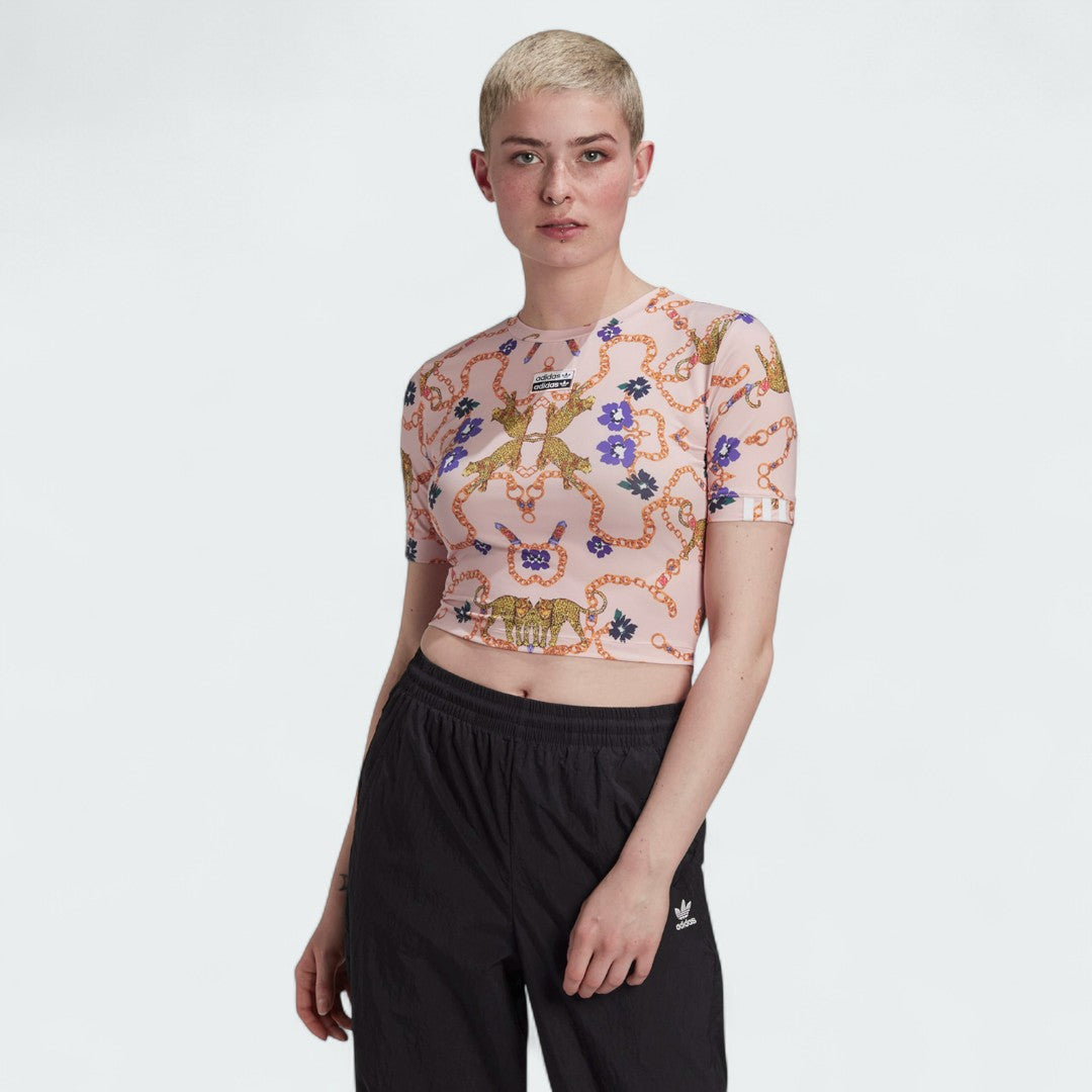 Woman wearing the Adidas x Her Studio London Cropped Tee with a multi-color floral print, demonstrating its stylish fit and cropped length.