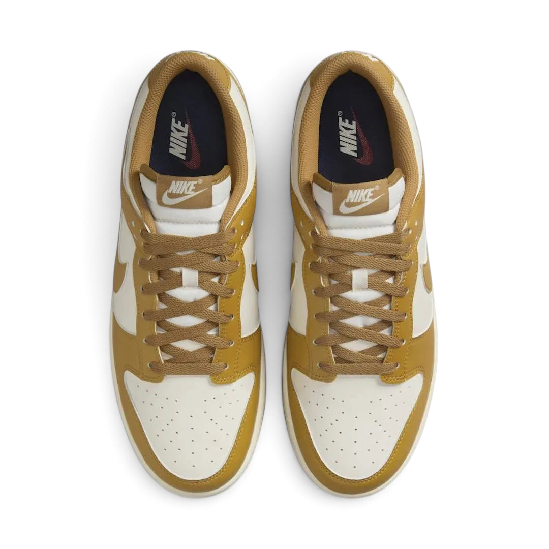 Top-down view of a pair of Nike Dunk Low Retro Men's trainers in wheat, highlighting their iconic silhouette and lace-up closure.