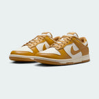 Angled view of two Nike Dunk Low Retro Men's wheat trainers, side by side, showcasing their timeless design and classic athletic aesthetic.