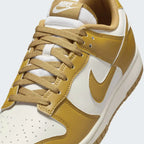 Close-up zoom on the front of the Nike Dunk Low Retro Men's wheat trainers, showing the perforated toe box, lace-up system, and textured leather upper.
