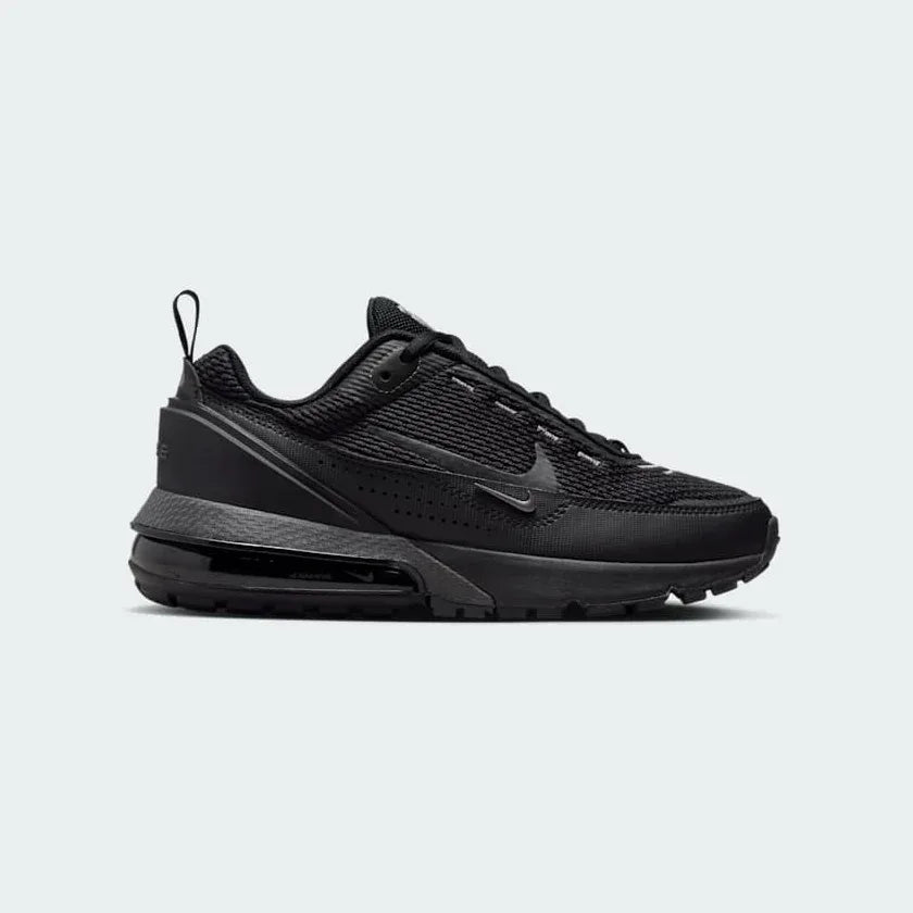 Nike Air Max Pulse Juniors' trainers in black and grey, side profile showing visible point-loaded Max Air unit and layered textile upper.