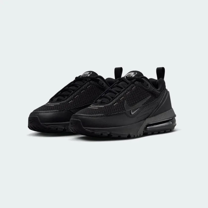 Angled view of two Nike Air Max Pulse Juniors' trainers in black and grey, side by side, showcasing their bold design and visible Air unit.