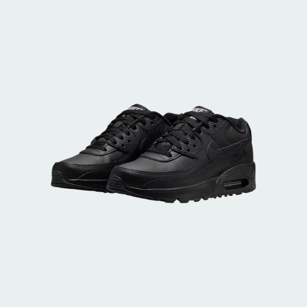 Angled view of two Nike Air Max 90 Juniors' black trainers, side by side, showcasing their timeless aesthetic and clean, dark colourway.