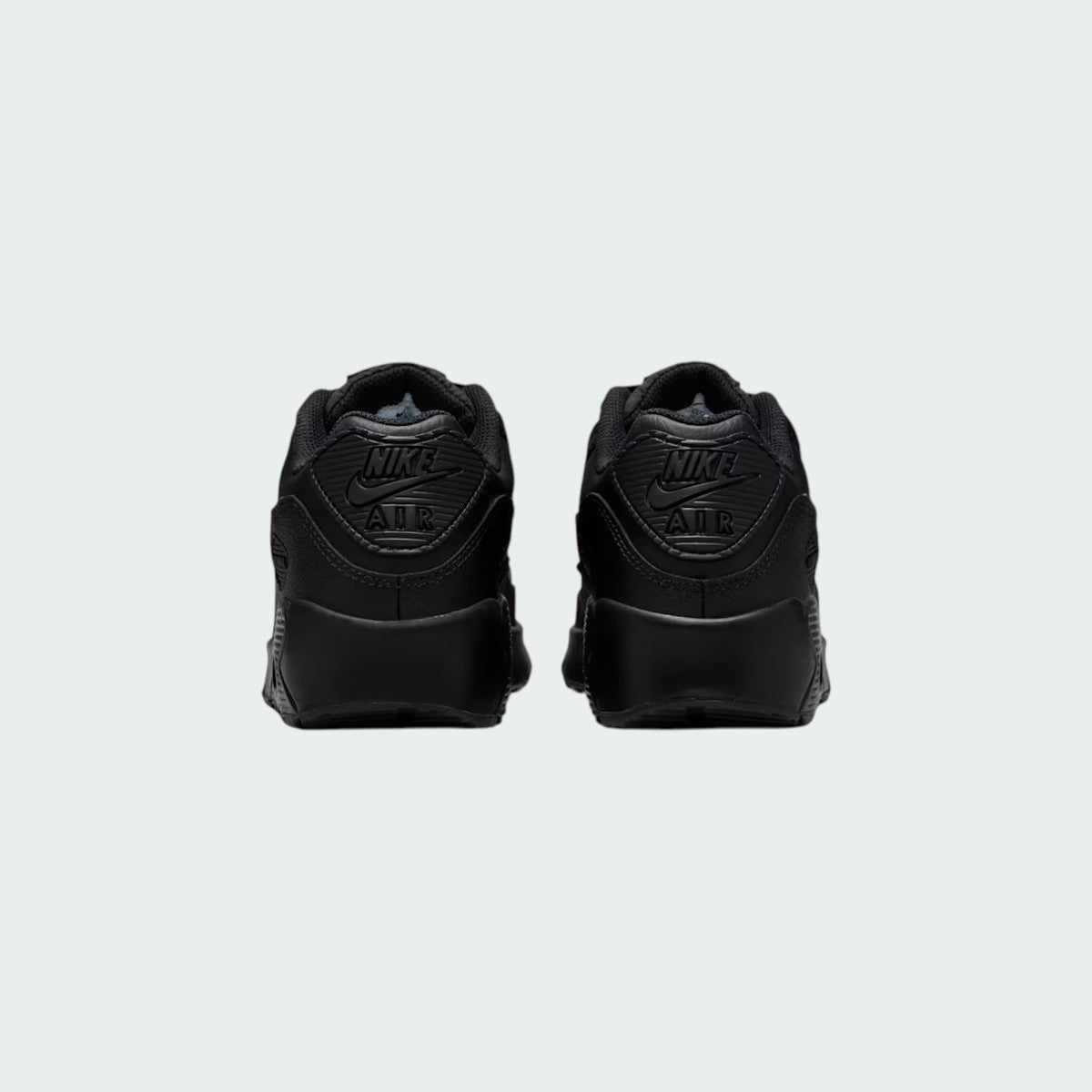 Rear view of the Nike Air Max 90 Juniors' black trainers, focusing on the prominent Nike Air branding on the heel tab.