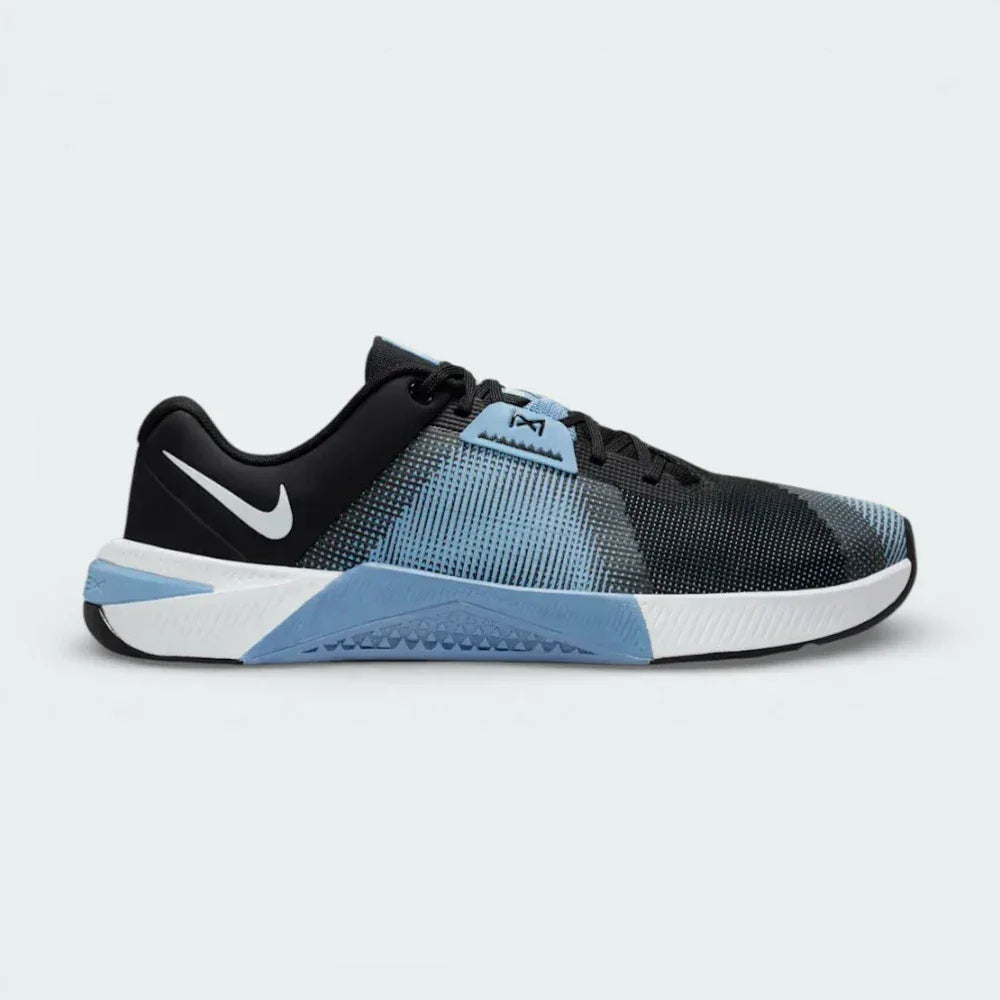 Alt Text: Side profile of the Nike Free Metcon in Vast Grey, showing the Black Swoosh and the vibrant Blue Hero accents on the flexible sole.
