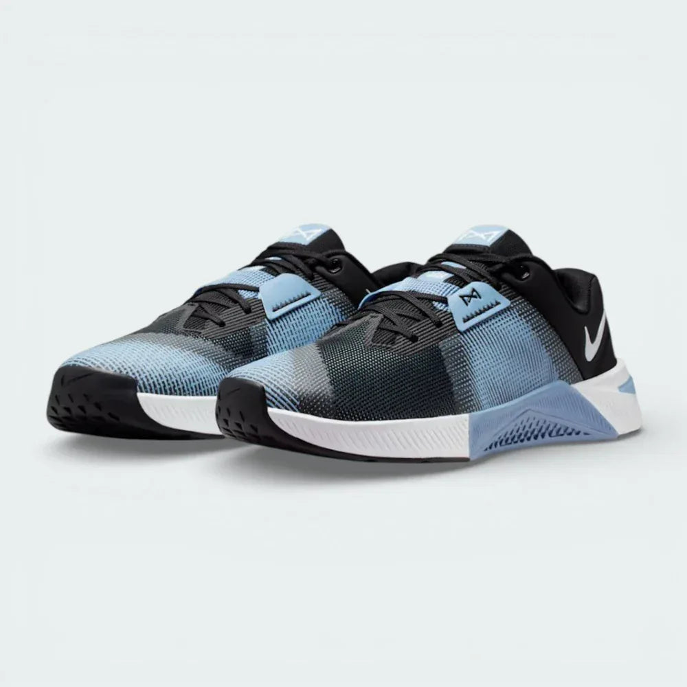 Angled shot of both Nike Free Metcon trainers, showcasing the athletic silhouette and the contrast between the grey panels and blue highlights.