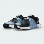 Angled shot of both Nike Free Metcon trainers, showcasing the athletic silhouette and the contrast between the grey panels and blue highlights.