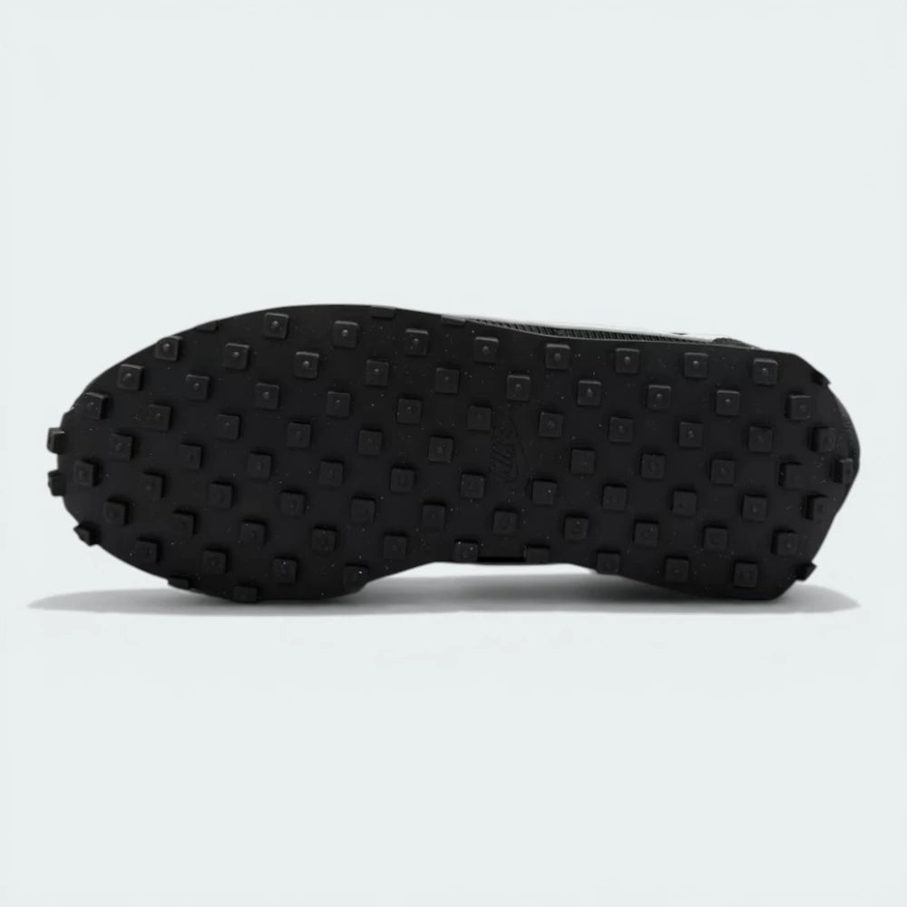 View of the black rubber Waffle outsole, showcasing the deep lugs and the extra-wide footprint of the flared heel.