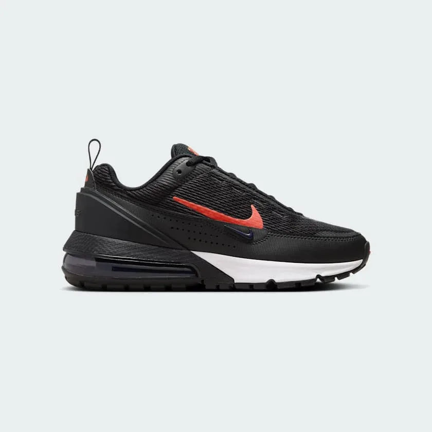 Nike Air Max Pulse Juniors' trainers in black with university red accents, side profile showing visible point-loaded Max Air unit and layered textile upper.