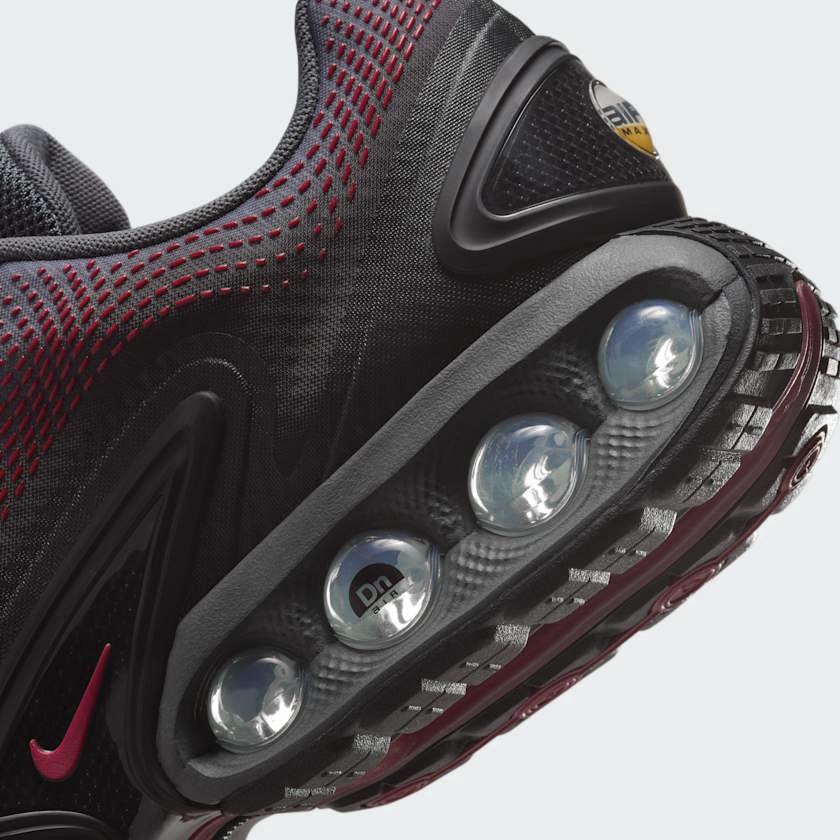 Close-up of Nike Air Max DN Men's Black Trainers HM0708-002 mesh upper, eyelets, and tongue logo