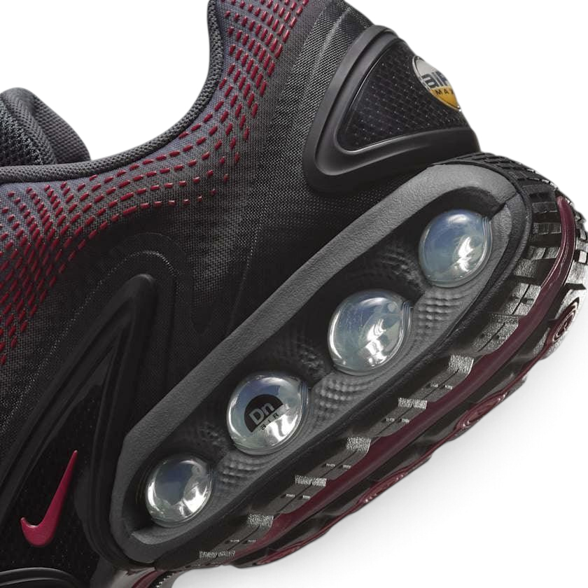 Close-up of Nike Air Max DN Men's Black Trainers HM0708-002 mesh upper, eyelets, and tongue logo