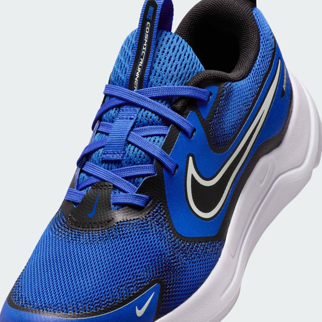Close-up zoom on the front of the Nike Cosmic Runner Juniors' blue running trainers, showing the mesh upper texture, lacing system, and synthetic overlays.