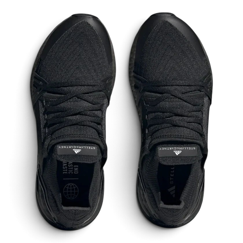 Top-down view of a pair of Adidas by Stella McCartney Ultra Boost 20 Women's trainers in black, highlighting their seamless Primeknit construction and unique lacing.