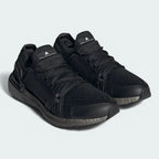 Angled view of two Adidas by Stella McCartney Ultra Boost 20 Women's trainers in black, side by side, showcasing their bold design and fashion-forward silhouette.