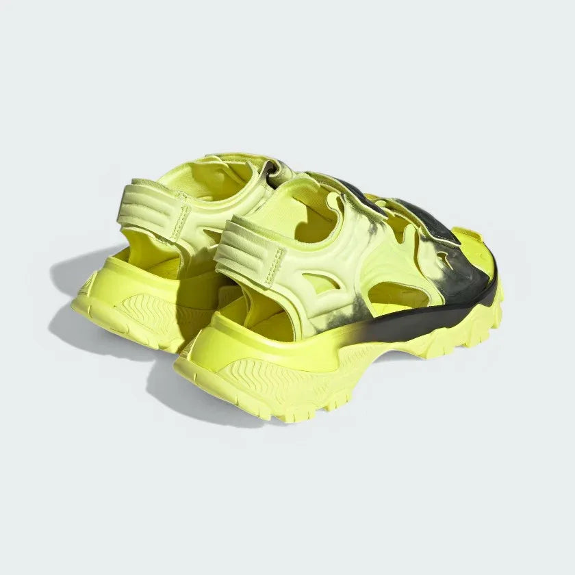 Angled view of two from the rear Adidas by Stella McCartney Hika Sandals in yellow and black, side by side, showcasing their robust yet stylish design.
