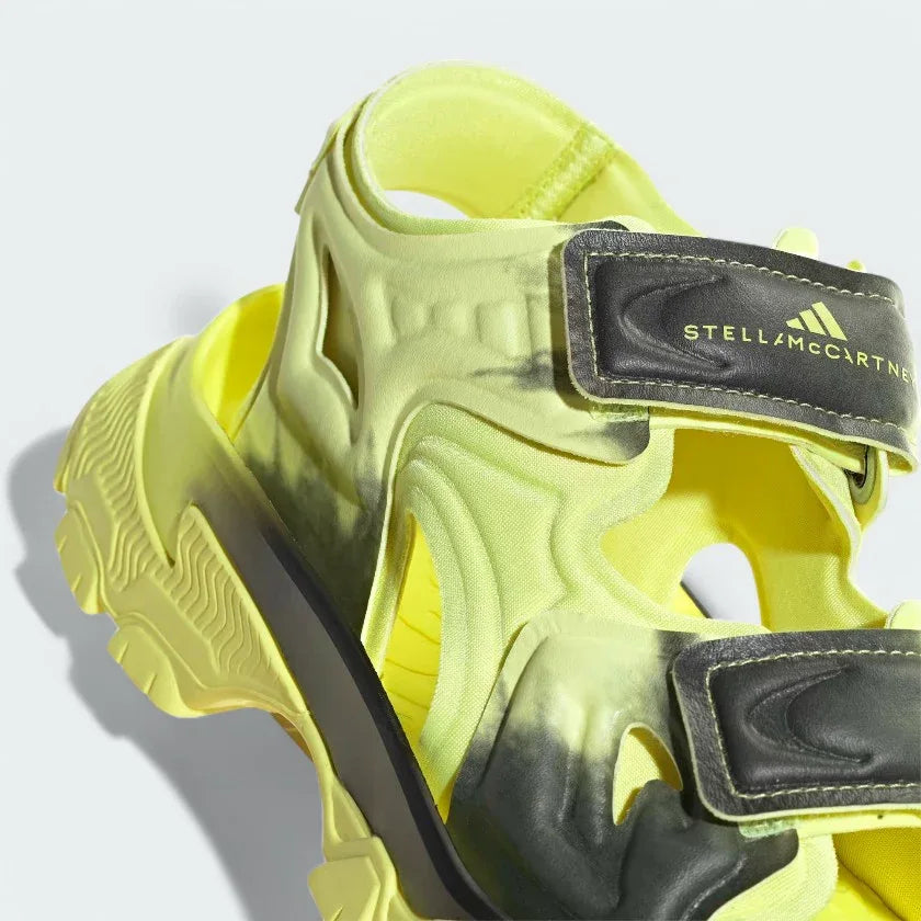 Close-up zoom on the straps of the Adidas by Stella McCartney Hika Sandal, showing the texture of the material and the collaborative Adidas by Stella McCartney logo.