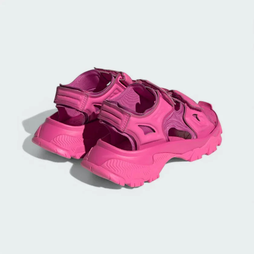 Angled view of two from the rear Adidas by Stella McCartney Hika Sandals in pink, side by side, showcasing their robust yet stylish design.