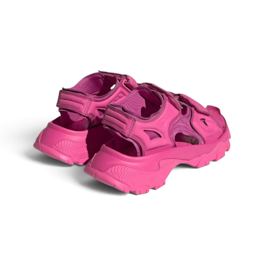 Angled view of two from the rear Adidas by Stella McCartney Hika Sandals in pink, side by side, showcasing their robust yet stylish design.