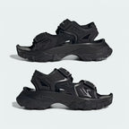 Angled view of two Adidas by Stella McCartney Hika Sandals in black, side by side, showcasing their robust yet stylish design.