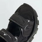 Close-up zoom on the straps of the Adidas by Stella McCartney Hika Sandal, showing the texture of the material and the collaborative Adidas by Stella McCartney logo.