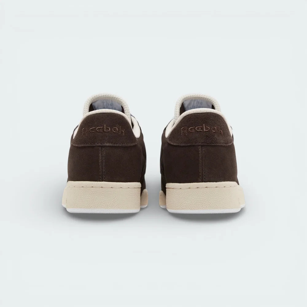 Rear view focusing on the structured suede heel and the precise stitching that connects the upper to the Stucco midsole.