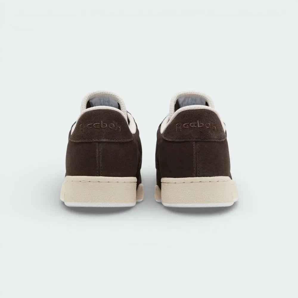 Rear view focusing on the structured suede heel and the precise stitching that connects the upper to the Stucco midsole.