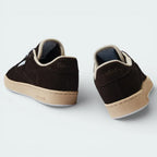 Rear view focusing on the structured suede heel and the precise stitching that connects the upper to the Stucco midsole.