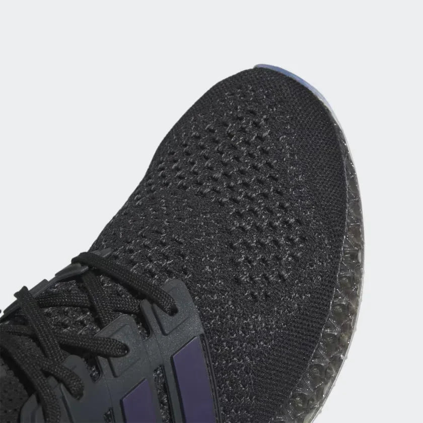 Close-up zoom on the front of the Adidas Ultra 4D x Rich Mnisi Pride men's trainers, showing the colorful Primeknit texture and unique lacing system.