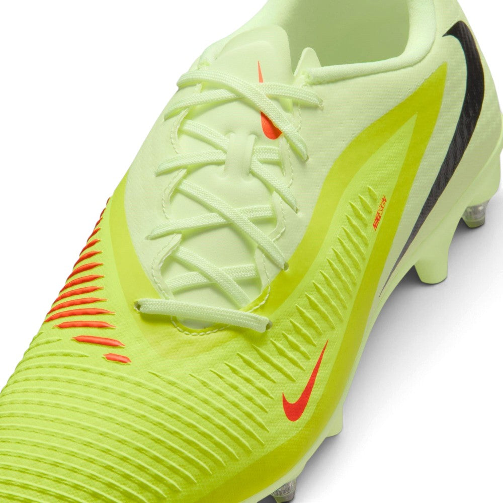 Macro focus on the forefoot and lacing area, detailing the textured NIKESKIN ribs, Hyper Crimson accent lines, and lime green laces.
