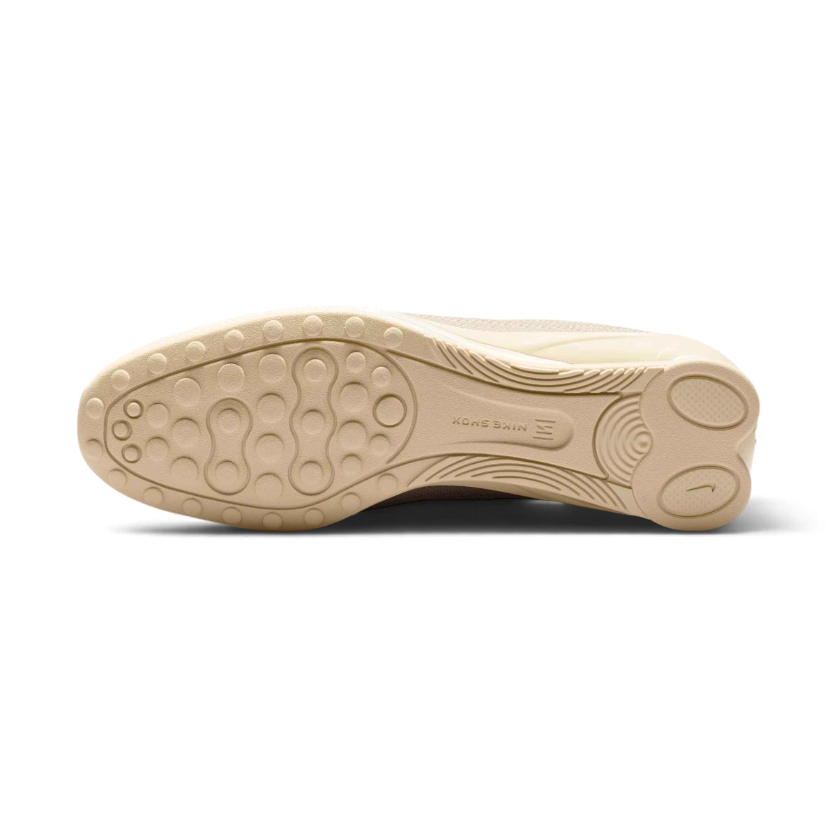 Outsole View: Bottom-down view of the beige rubber outsole, showcasing the circular traction pods, curved arch shank, and embossed Nike Shox branding block.