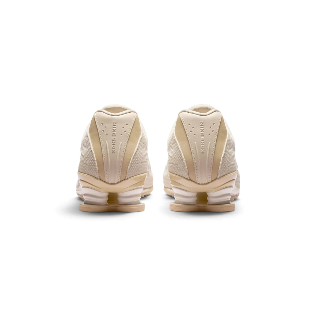 View from Behind Looking at the Rear: Rear-facing perspective focusing on the structured synthetic heel panels with embossed "NIKE SHOX" lettering and the dual Shox mechanical columns.   